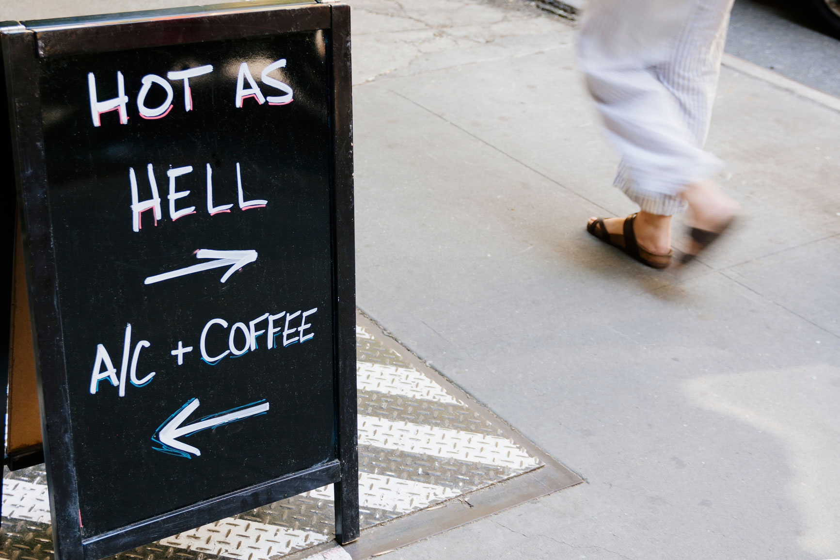 Sign promoting benefits of air conditioning on a hot day.